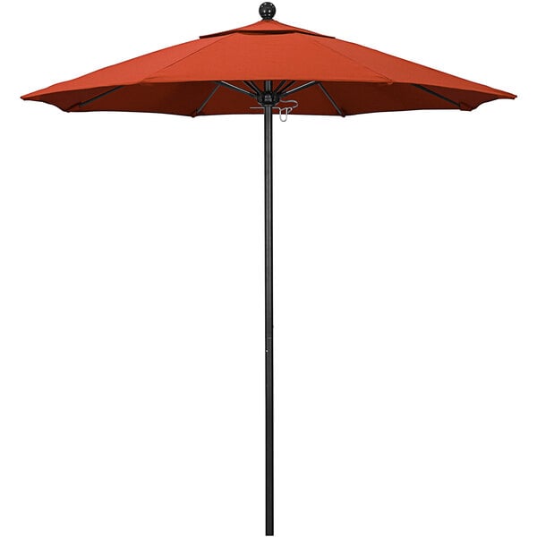 A California Umbrella sunset red round outdoor umbrella with a black pole.