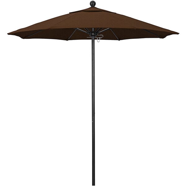 A brown California Umbrella with a black pole on a table.
