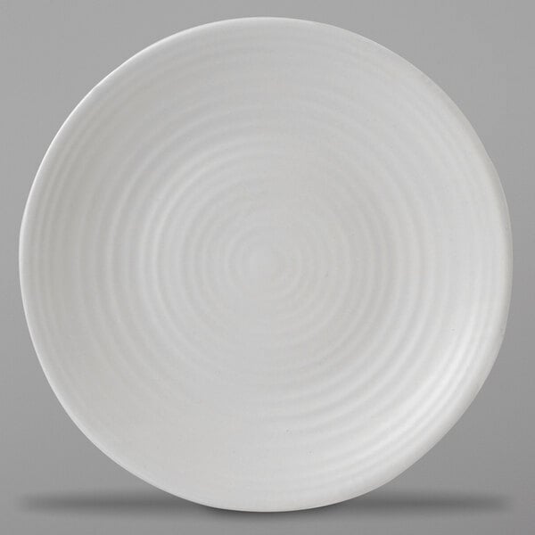 A close-up of a white Dudson stoneware plate with a spiral pattern.