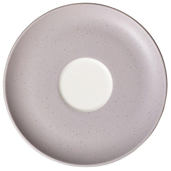 A white porcelain saucer with a gray speckled rim.