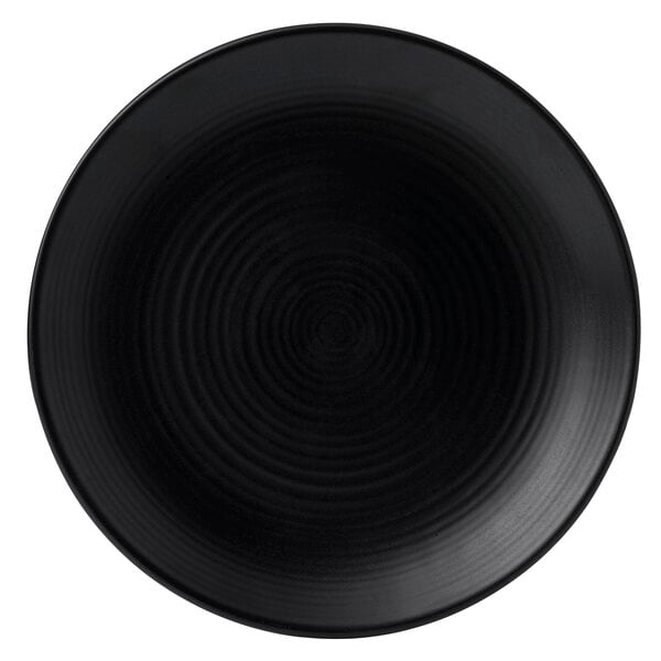 A black Dudson stoneware plate with a circular spiral pattern.