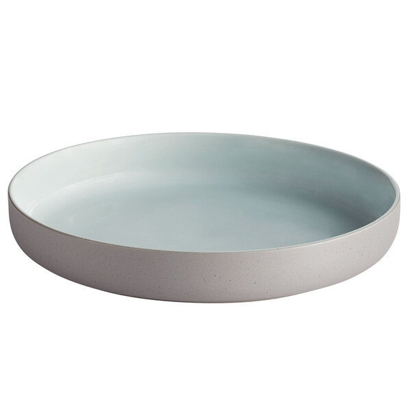 A Luzerne Hamptons porcelain deep plate with a raised rim and light blue and gray speckles.