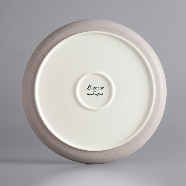 A white porcelain coupe plate with a gray speckled rim.