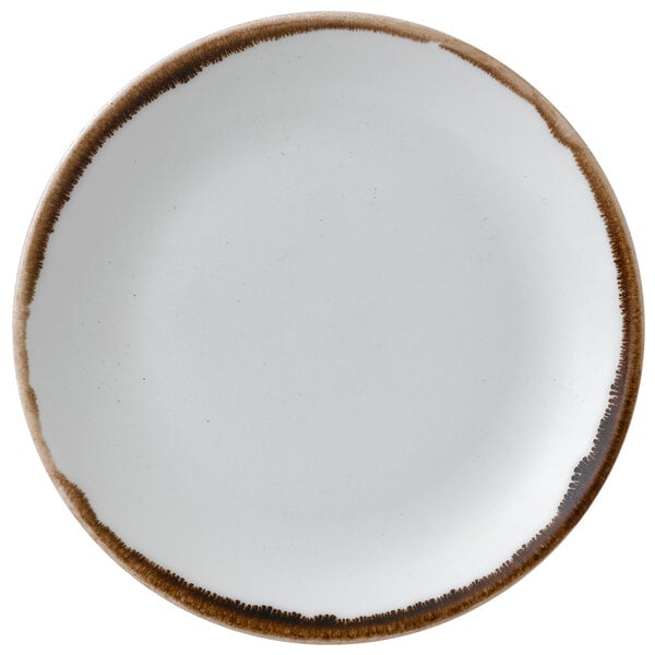 A white plate with brown speckles and a brown rim.