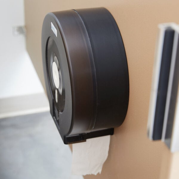 A black Merfin toilet paper dispenser on a wall.