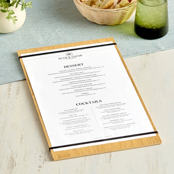 An American Metalcraft bamboo wood menu holder on a table with a menu.