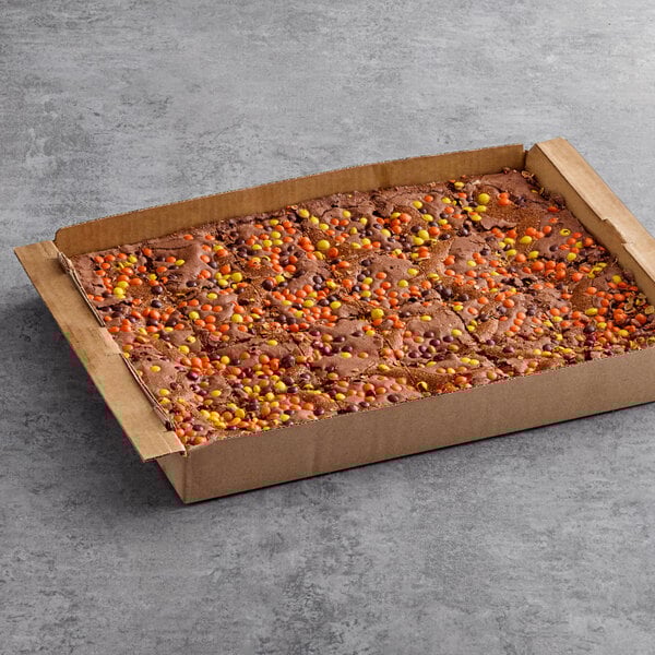 A box of David's Cookies Reese's Peanut Butter Swirl brownies on a table in a bakery display.