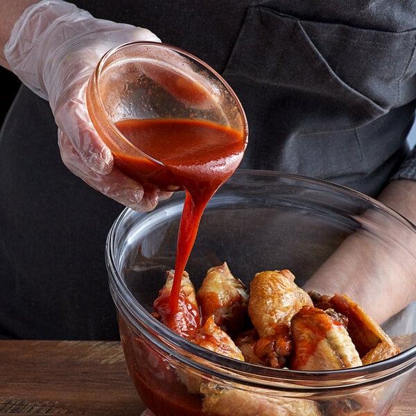 a person holding a container of tomato sauce