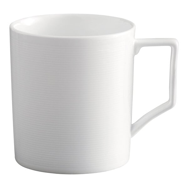 A bright white porcelain mug with embossed lines and a geometric handle.