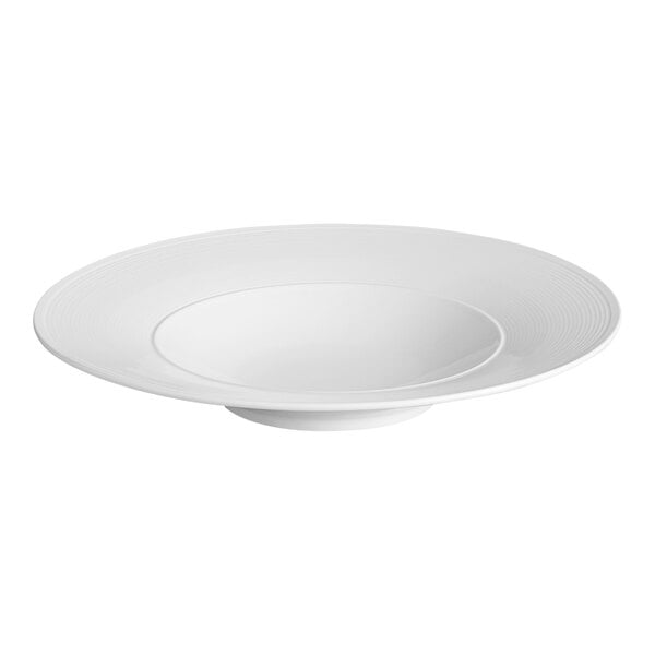 A white porcelain pasta bowl with embossed lines and a wide rim.