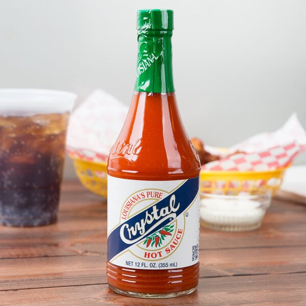 A Crystal 12 oz. bottle of hot sauce on a table.