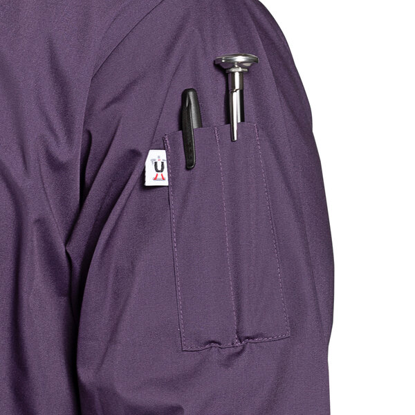 A close-up of the pocket on a purple Uncommon Chef 3/4 Length Sleeve Chef Coat.