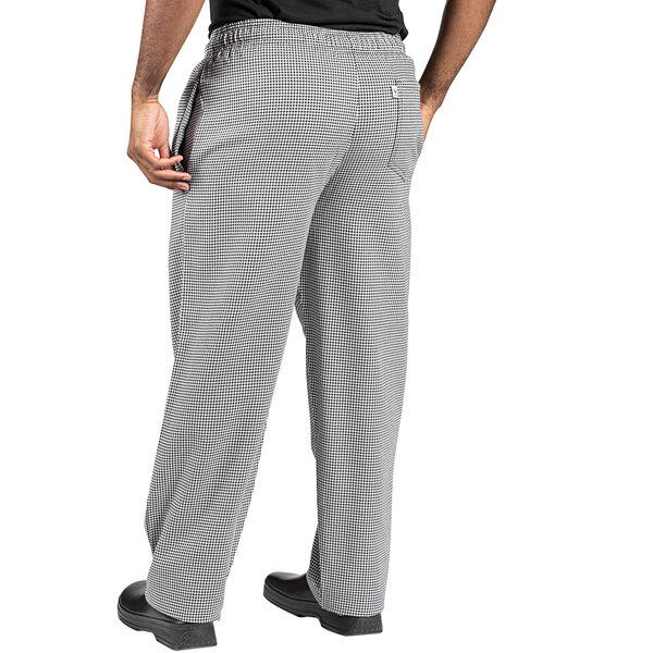 Uncommon Chef customizable houndstooth chef pants in grey and white with a person wearing them with their hands in their pockets.