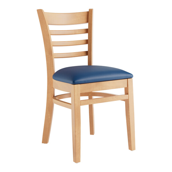 A Lancaster Table & Seating wooden chair with a navy blue vinyl cushion.
