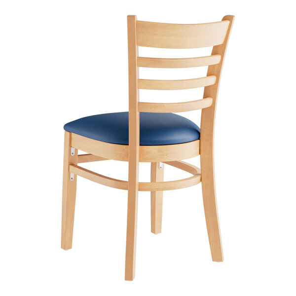 A Lancaster Table & Seating wooden restaurant chair with navy vinyl seat and ladder back.