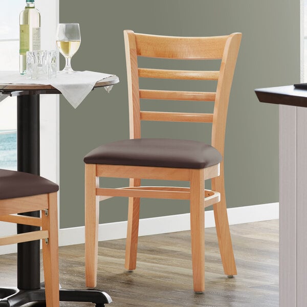 A Lancaster Table & Seating wooden chair with a dark brown vinyl seat.