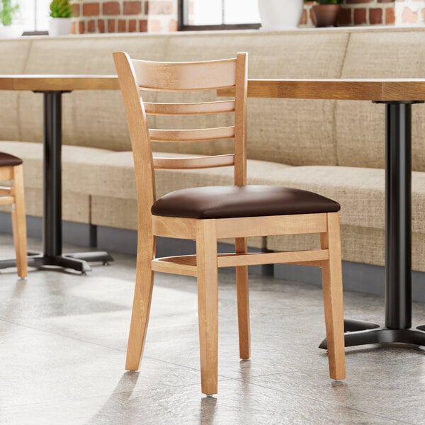 A Lancaster Table & Seating wooden restaurant chair with a dark brown vinyl seat.