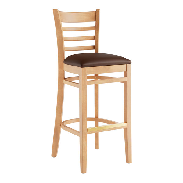 A Lancaster Table & Seating wooden ladder back bar stool with a dark brown vinyl seat.