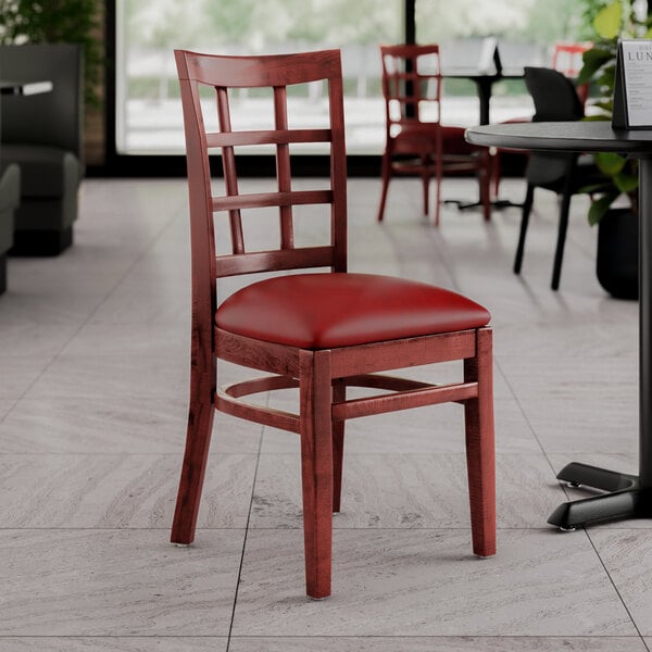 A Lancaster Table & Seating mahogany wood chair with a burgundy vinyl seat.