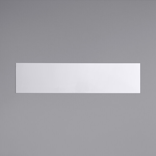 A white rectangular object on a gray surface.