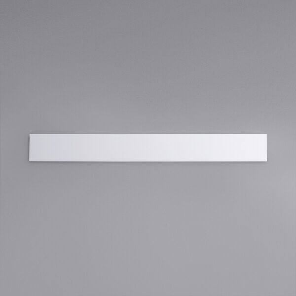 A white rectangular object with a black border on a gray background.