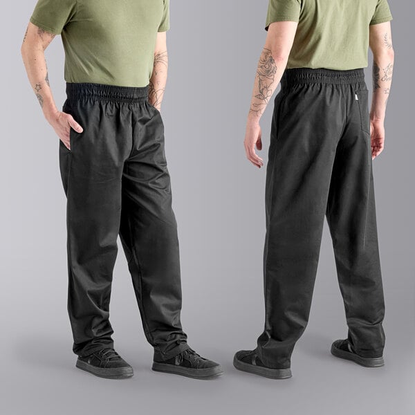 The lower half of a man wearing Uncommon Chef black classic chef pants and a green shirt.