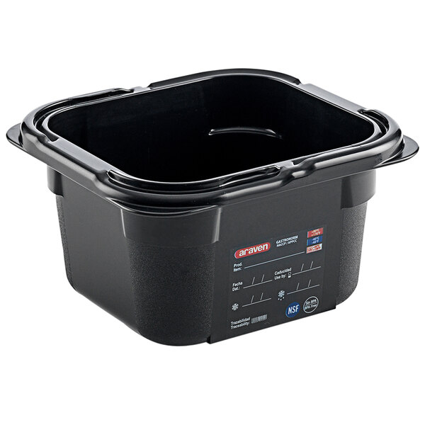 An Araven black plastic food pan on a counter with a label.