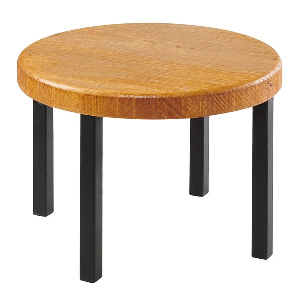 A Cal-Mil Madera rustic pine round wood riser on a round wooden table with black legs.