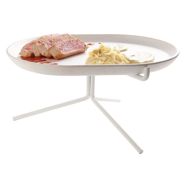 A white Cal-Mil plate of food on a stand.