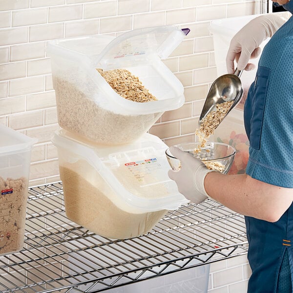 A person pouring cereal from a box into an Araven polypropylene ingredient bin.