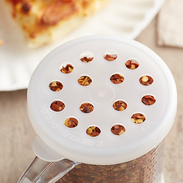 A Carlisle translucent shaker lid with holes over a container.