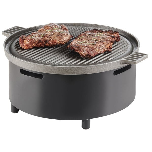 A Cal-Mil round chafer alternative with meat on a grill.
