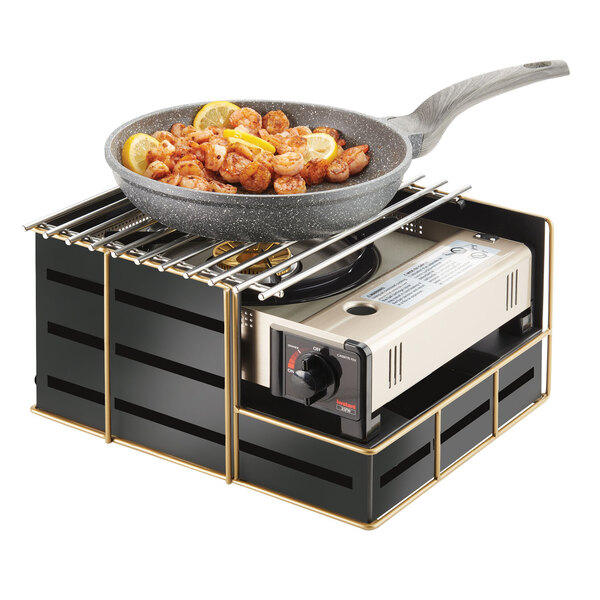 A pan with shrimp and lemons on top of a Cal-Mil black metal butane stove frame.