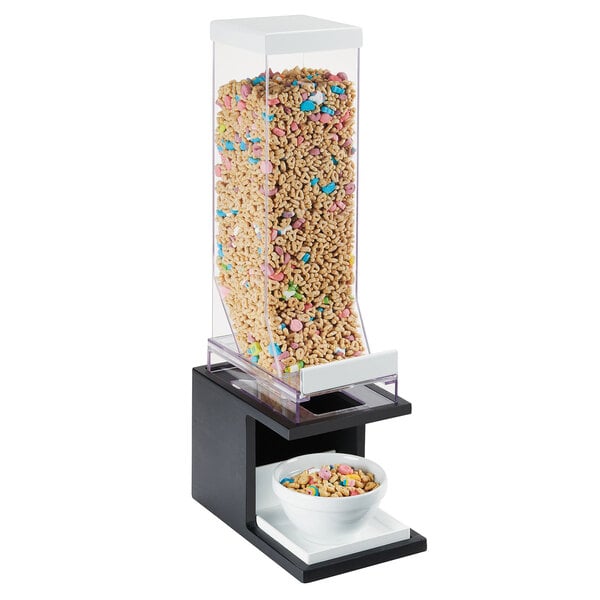 A black Cal-Mil cereal dispenser filled with cereal next to a bowl.