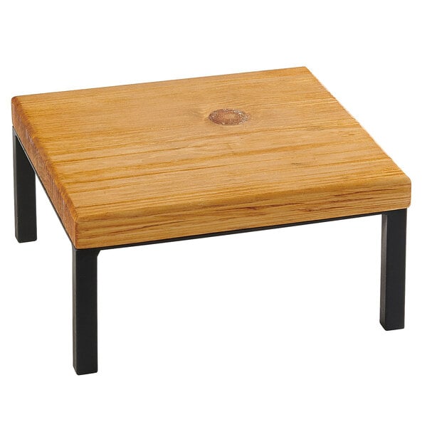 A Cal-Mil Madera rustic wood square riser on a wooden table with black legs.