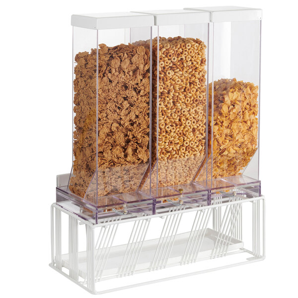 A Cal-Mil white triple cereal dispenser with clear plastic containers full of different kinds of cereal.