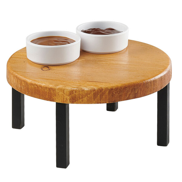 A Cal-Mil Madera rustic pine round wood riser holding two bowls of sauce on a table.