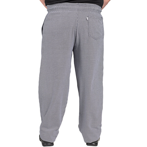 Uncommon Chef houndstooth chef pants with a pocket being worn by a person with a black shirt.