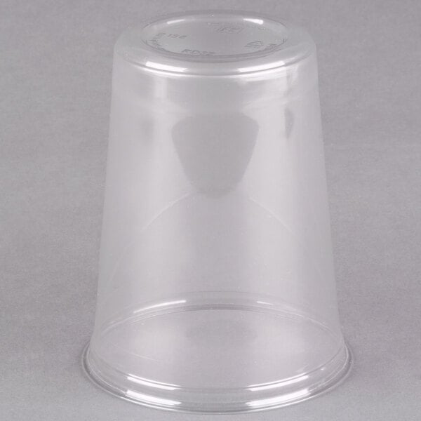 A clear plastic cup on a gray background.