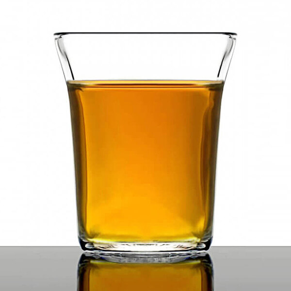 A Duralex glass filled with brown liquid.