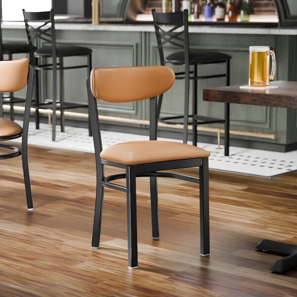 A black metal chair with a light brown vinyl seat and backrest.