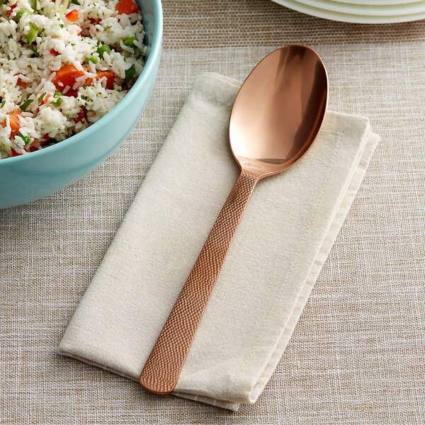 a spoon on a napkin next to a bowl of rice