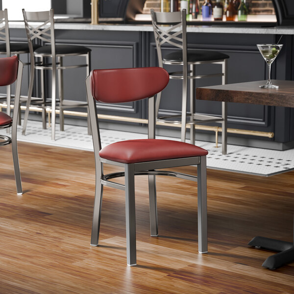 A metal chair with a clear coat finish, featuring a burgundy vinyl seat and backrest.