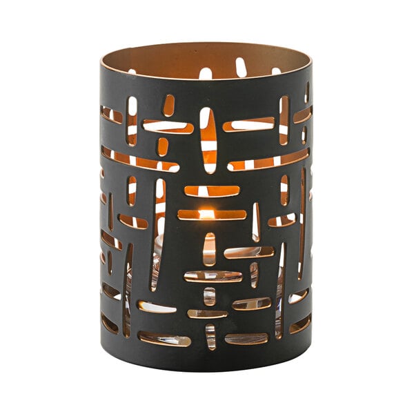 A black metal Hollowick votive holder with a cut-out design holding a lit candle.