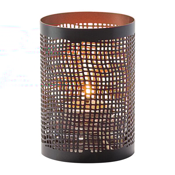 A Hollowick Chantilly black metal votive candle holder with a lit candle inside.