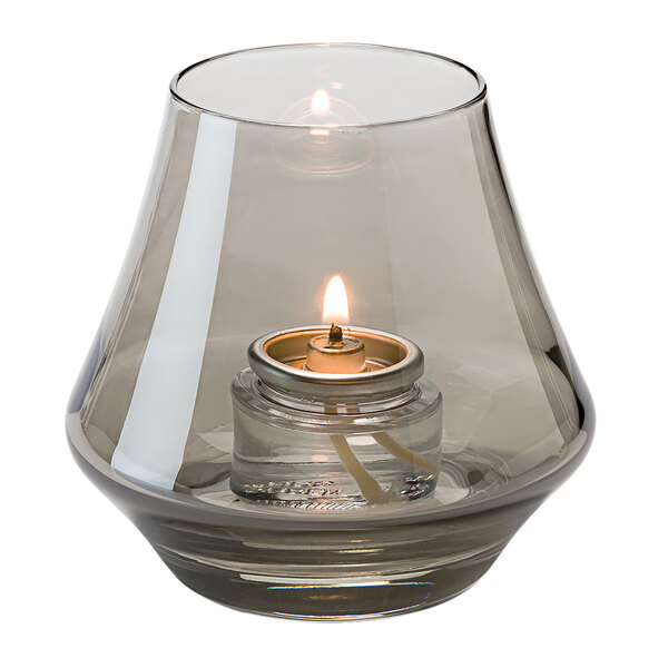 a glass candle holder with a flame inside