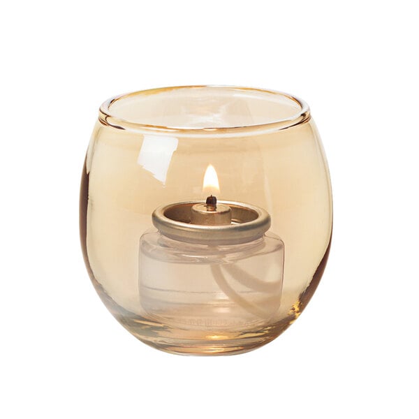 A small gold glass bubble tealight candle holder with a lit candle inside.