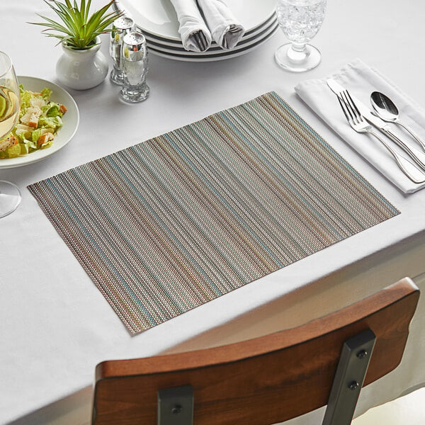 A table set with blue Metroweave vinyl placemats, plates, and silverware.