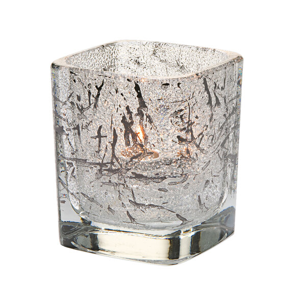 A black glass Hollowick square votive with a candle inside.