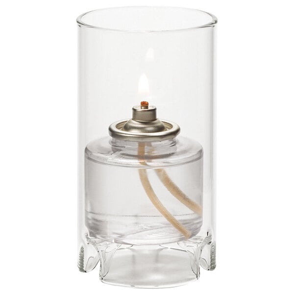 A Hollowick clear glass cylinder candle holder with a flame inside.